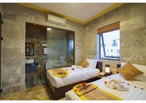 een hotelkamer met 2 bedden en een douche bij Hoi AN Hometown in An Bàn (2)
