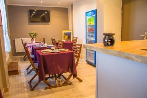 a dining room with a table with purple table cloth at Hôtel Trianon in Juan-les-Pins