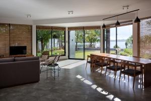 a dining room with a table and chairs and a couch at LAKE VILLA by CARLSEN in Moratuwa