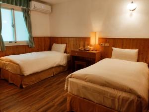 a hotel room with two beds and a window at Chinshang Pastoral Farm Resort in Chishang