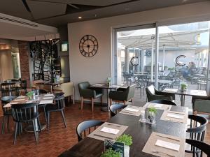 a restaurant with tables and chairs and a large window at 501 Canal Quays in Cape Town