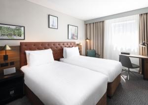 エディンバラにあるアペックス ヘイマーケット ホテルのベッド2台とデスクが備わるホテルルームです。