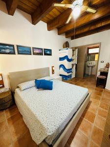 una camera da letto con un letto con cuscini blu di EL MATORRAL ad Alghero