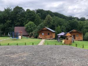 a group of cabins with a playground and a house at Agroturystykadomkistawisko in Solina