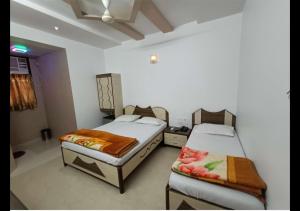 a room with two beds in a room at Hotel Broadway Colaba in Mumbai