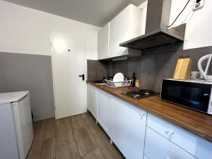 a kitchen with white cabinets and a counter top at Monteurunterkunft Schwaig in Schwaig bei Nürnberg +13 photos
