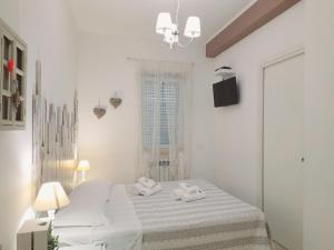 a white bedroom with a bed and a window at Il Mare Di Roma in Lido di Ostia