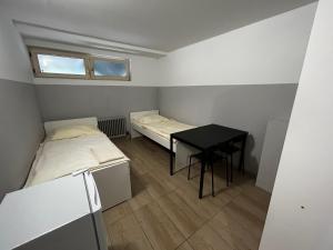 a small room with two beds and a table at Monteurunterkunft Schwaig in Schwaig bei Nürnberg