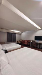 a hotel room with two beds and a couch at Crystal City Hotel in Zhongli