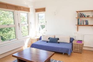 a living room with a bed and a table and windows at River View at White Horses, Bantham, South Devon with glorious estuary views in Bigbury on Sea