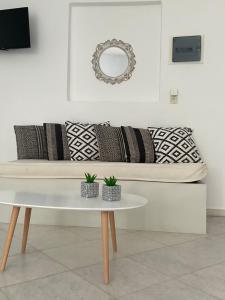 a white couch with pillows and a table in a room at Rodia Studios & Apartments in Parikia