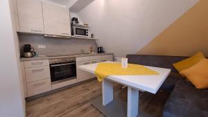 - une petite cuisine avec une table blanche dans une chambre dans l'établissement Ferienwohnung am Altmühlsee, à Gunzenhausen