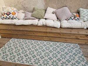 a couch with pillows on it with a rug at jolie maison à 10 mn à pied du centre d'Aix-en-Provence in Aix-en-Provence