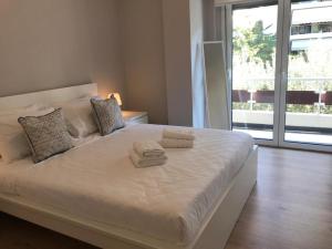 een wit bed met twee handdoeken erop bij Spacious Apartment In N. Smirni in Athene