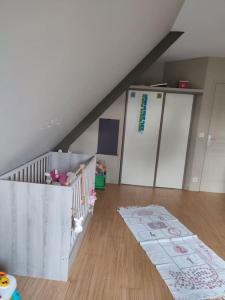 Pokój z drewnianymi podłogami i schodami z łóżeczkiem dziecięcym w obiekcie Maison individuelle 3 chambres w mieście Pleudihen-sur-Rance