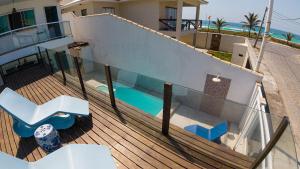 カボ・フリオにあるCasa Blanca 3 suítes Praia Lagoa SPA aquecido Piscinaのスイミングプール付きの家のバルコニー