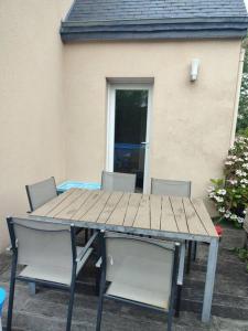 drewniany stół i krzesła na dziedzińcu w obiekcie Maison individuelle 3 chambres w mieście Pleudihen-sur-Rance