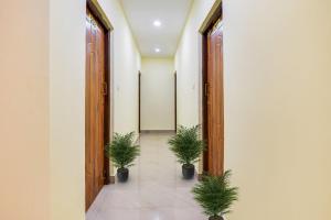an empty corridor with potted plants in a building at Hotel Joaquim Near Baga Beach in Baga