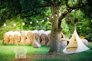 a tent and a chair under a tree with hay at Ranna Surfiküla in Suureranna