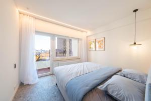 a bedroom with a bed and a large window at Luxury Design Apartment with free private parking in Ostend