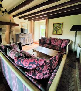a living room with a couch and a table at Manoir normand du XIVe siecle. in Le Lorey
