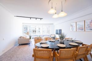 una sala da pranzo con tavolo e sedie neri di Luxury Design Apartment with free private parking a Ostenda