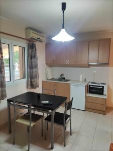 a kitchen with a black table and chairs and a kitchen with a stove at ROMVI VILLAGE in Amaliás