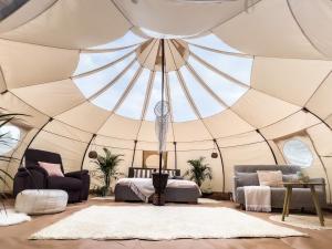 a large tent with a bed and chairs in a room at Ranna Surfiküla in Suureranna