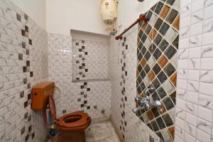 une salle de bain avec toilettes et un mur carrelé dans l'établissement Inda Heritage Guest House, à Jodhpur
