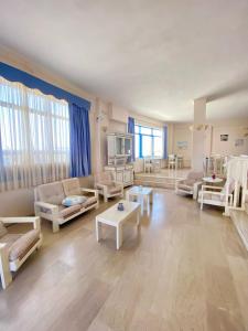 una gran sala de estar con sofás y mesas. en Pallada Hotel en Agia Galini