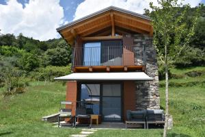 a small house with a balcony and a deck at Grandin Holidayhouse in Domaso