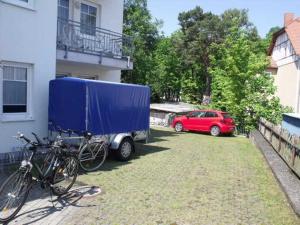 アールベックにあるEG 05 Ferienwohnung am Wilhelmsbergの家の隣に車と自転車が停まっている