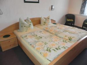 アールベックにあるFerienhaus Marthaのベッドルーム1室(花の毛布付きのベッド1台付)