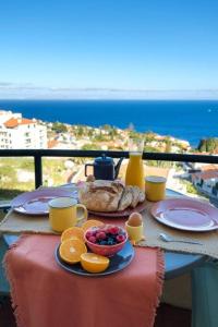 - une table avec une assiette de nourriture et de fruits dans l'établissement GuestReady - An amazing stay with Island views, à Caniço