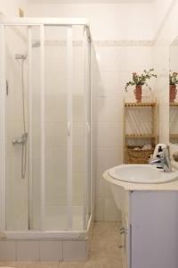 uma casa de banho branca com um chuveiro e um lavatório. em GuestReady - An amazing stay with Island views no Caniço