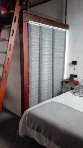 1 dormitorio con ventana grande y escalera junto a la cama en Vivienda Vacacional San Roque, 30 en Garachico