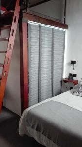 a bedroom with a large window with a ladder next to a bed at Vivienda Vacacional San Roque, 30 in Garachico