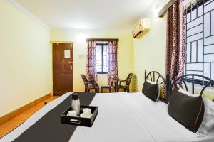 una camera con letto e sedie di Hotel Joaquim Near Baga Beach a Baga