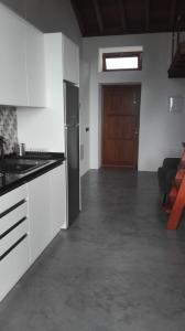 a kitchen with white cabinets and a wooden door at Vivienda Vacacional San Roque, 30 in Garachico