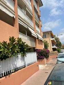 a building with a white fence next to a street at Appartement 2 pièces-4 personnes in Roquebrune-Cap-Martin