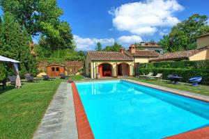 a swimming pool in the yard of a house at Santa Flora by PosarelliVillas in Capolona