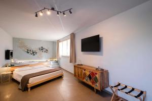 a bedroom with a bed and a tv on the wall at Tenuta Donna Caterina by BarbarHouse in Mesagne