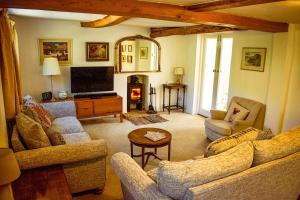 Monks Eleigh的住宿－Cosy Cottage with Log Burner, Large Garden, Dog Friendly!，客厅配有两张沙发和一台电视机