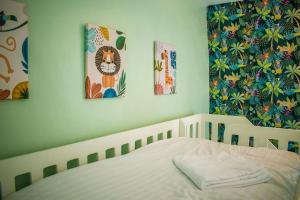 ein Schlafzimmer mit drei Gemälden an der Wand und einem Bett in der Unterkunft Cosy Cottage with Log Burner, Large Garden, Dog Friendly! in Monks Eleigh