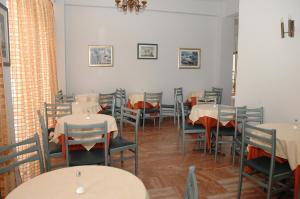 a dining room with tables and chairs and a room with at Koronis Hotel in Tolo