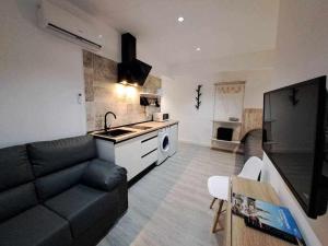 a living room with a black couch and a kitchen at ACC Serrano 2 aparcamiento cercano in Jaén