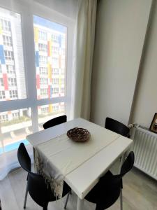 een witte tafel met stoelen in een kamer met een raam bij Selin's apartment with pool view in Antalya