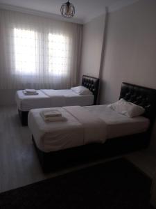 2 Betten in einem Hotelzimmer mit Fenster in der Unterkunft PEKER Apart in Pelitli