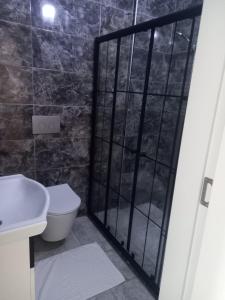 ein Bad mit einem WC und einer Hintertür mit einer Dusche in der Unterkunft PEKER Apart in Pelitli