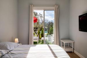 Un dormitorio con una cama y una puerta a un patio. en Landaise le lagunak avec piscine chauffée à 900 M de la plage, en Labenne 36 fotos más